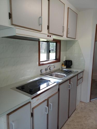 a small kitchen with a sink and a stove at Casuarina Cabins in Nelson