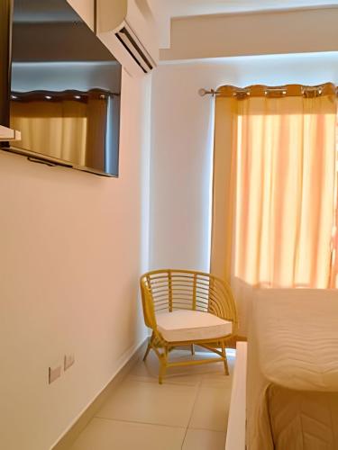 a room with a chair and a window at Caribbean Sunset Soak In Juan Dolio Beach Apt. in Juan Dolio