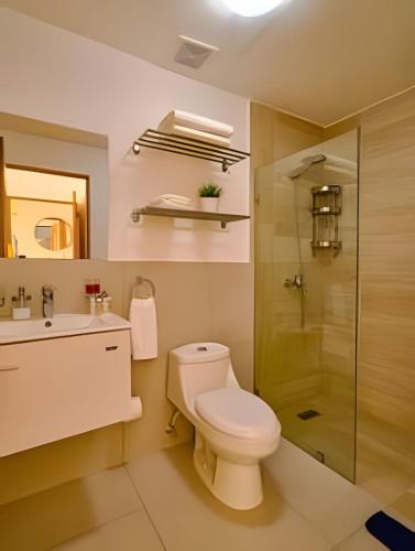 a bathroom with a toilet and a sink and a shower at Caribbean Sunset Soak In Juan Dolio Beach Apt. in Juan Dolio