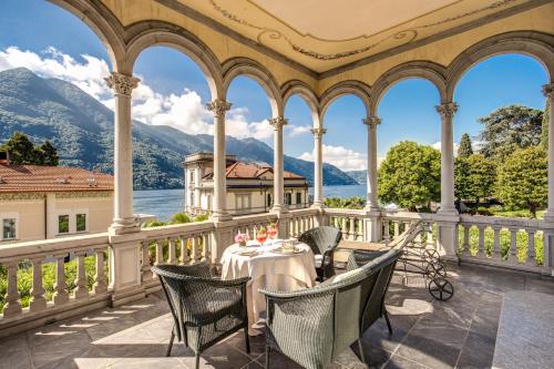 a table on a balcony with a view of the mountains at Grand Hotel Imperiale Resort & SPA in Moltrasio