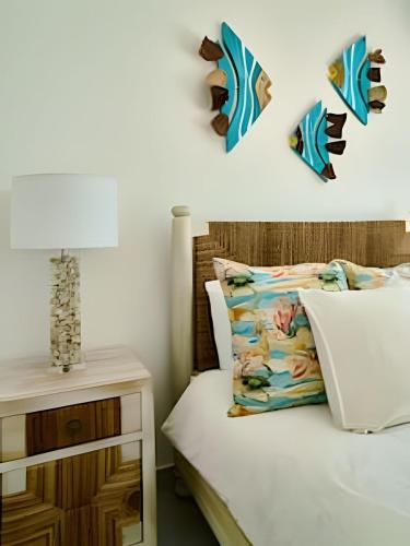 a bedroom with a bed and a nightstand with a lamp at Caribbean Sunscape Beachfront Apartment in La Puntica de Juan Dolio