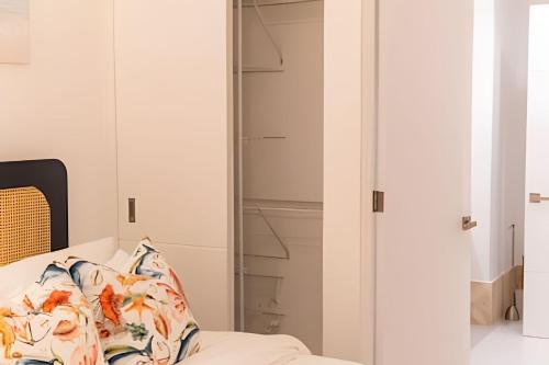 a bedroom with a bed and a glass closet at Caribbean Sunscape Beachfront Apartment in La Puntica de Juan Dolio
