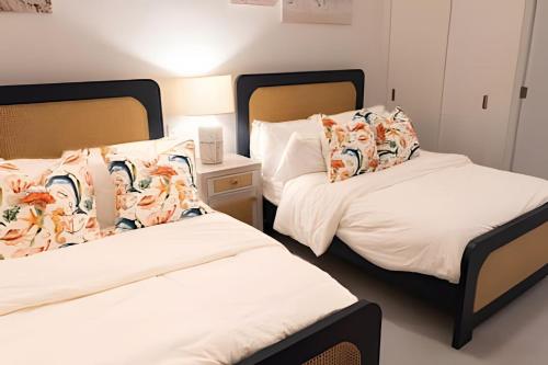 two beds sitting next to each other in a room at Caribbean Sunscape Beachfront Apartment in La Puntica de Juan Dolio