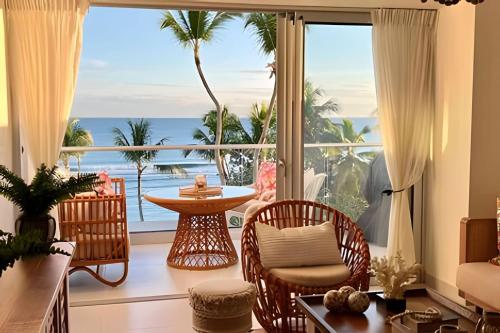 a living room with a view of the ocean at Caribbean Sunscape Beachfront Apartment in La Puntica de Juan Dolio