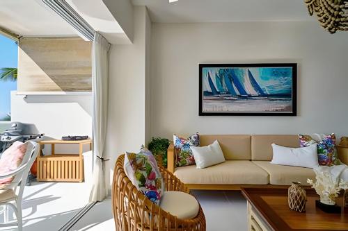 a living room with a couch and a table at Caribbean Sunscape Beachfront Apartment in La Puntica de Juan Dolio