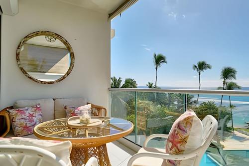 a balcony with a table and chairs and a view of the ocean at Caribbean Sunscape Beachfront Apartment in La Puntica de Juan Dolio