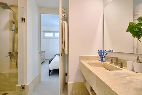 a bathroom with a sink and a mirror at Caribbean Sunscape Beachfront Apartment in La Puntica de Juan Dolio