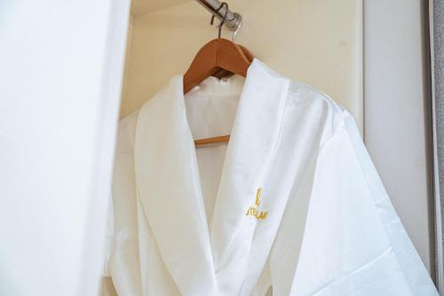 a white shirt hanging on a rack in a door at Lake Tourist Hotel in Seoul