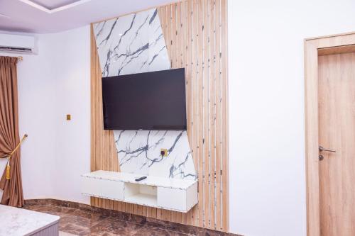 a living room with a tv on a wall at Hilton Palace Hotel in Kano