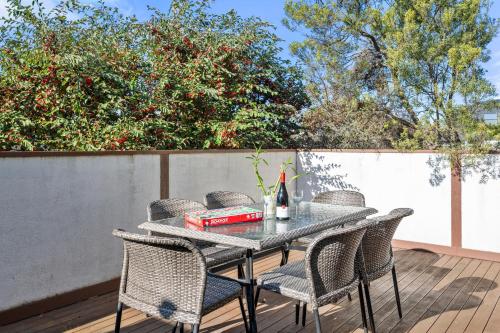 a patio table with chairs and a bottle of wine at Epic Rye Penthouse with Bubble Dome & Amazing Views! in Rye