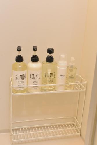 a shelf with four bottles of laundry detergent in a refrigerator at Kamakura Jomyoji Terrace-鎌倉浄明寺テラス- in Kamakura