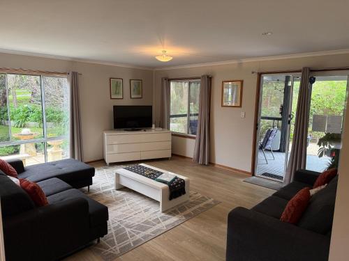 a living room with two couches and a tv at Cozy Cottage Victor Harbor in Hindmarsh Valley