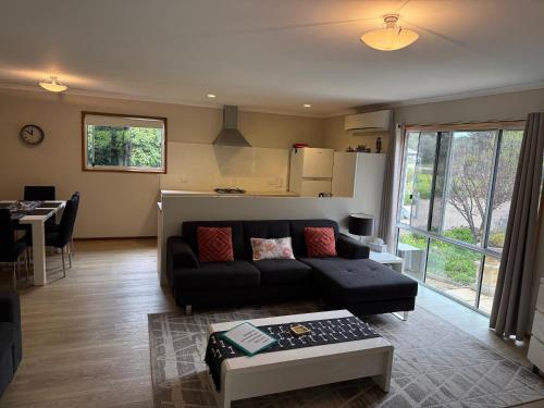 a living room with a couch and a table at Cozy Cottage Victor Harbor in Hindmarsh Valley