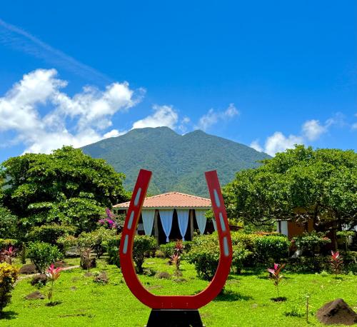 a red sculpture in front of a house with a mountain at Finca Montaña Sagrada in Mérida