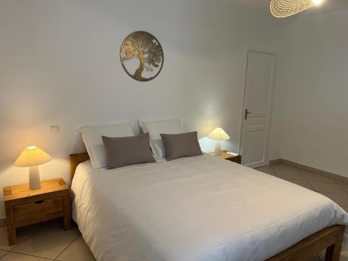una camera da letto con un grande letto bianco con due lampade di Les Reflets dAngele Terrasse XXL a Sete a Sète