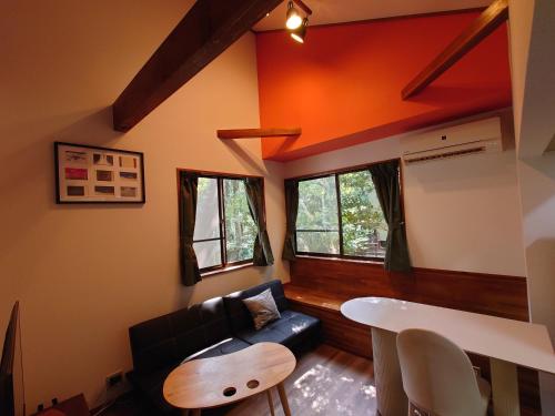 a living room with a couch and a table at 熱川ヒュッテ in Higashiizu