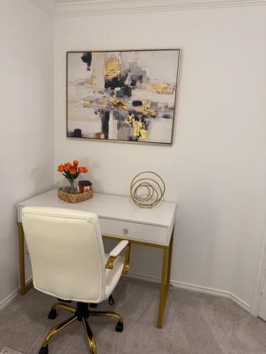 a white desk with a white chair and a painting at Lakemeadow in Princeton