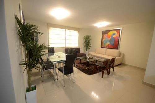 sala de estar con sofá, mesa y sillas en Luxury Apartments Miraflores, en Lima