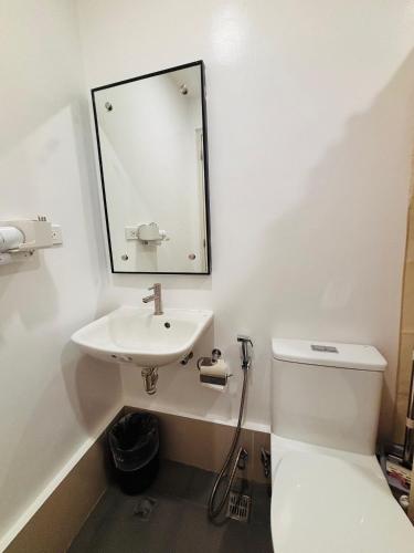 a white bathroom with a sink and a toilet at Elegant Room with Relaxing Ambiance in Mandurriao