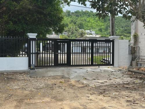 a black gate in front of a house at Playa Del Pedro Beach House in Guam
