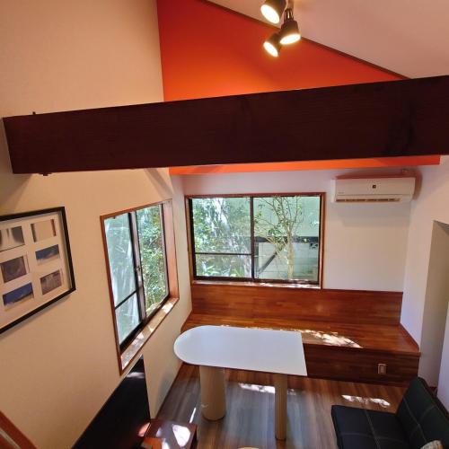 a room with a white table and two windows at 熱川ヒュッテ in Higashiizu