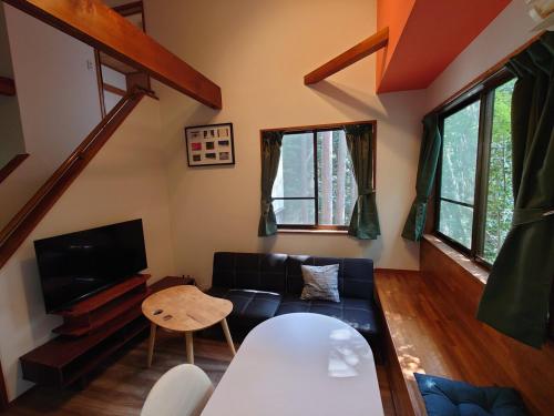 a living room with a couch and a table at 熱川ヒュッテ in Higashiizu