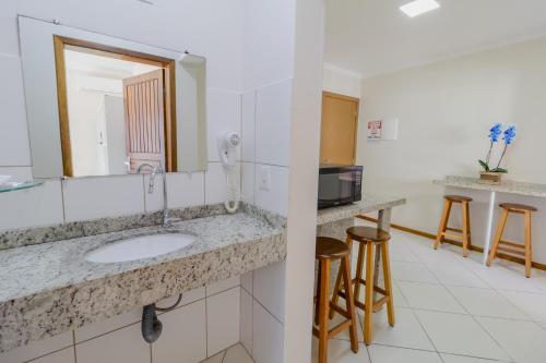 a bathroom with a sink and a mirror at Hotel Monteiro Canasvieiras in Florianópolis
