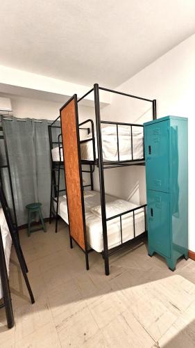 a room with two bunk beds and a green locker at JATIVI Guest in Pucallpa