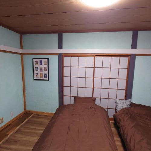 a bedroom with two beds in a room with blue walls at 熱川ヒュッテ in Higashiizu