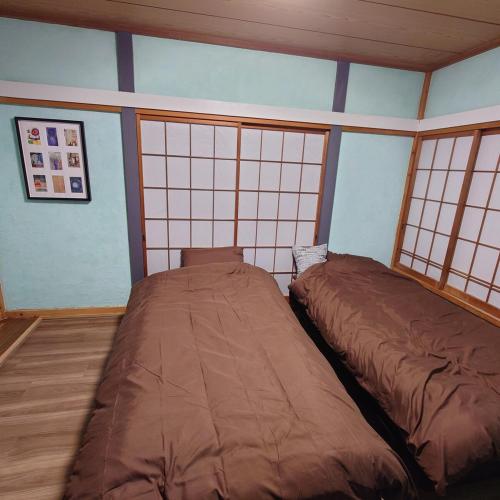 a bedroom with two beds in a room at 熱川ヒュッテ in Higashiizu