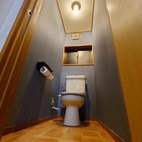 a bathroom with a toilet in a small room at 熱川ヒュッテ in Higashiizu