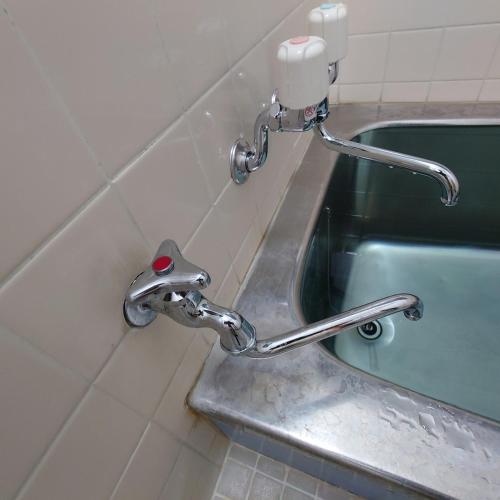 a metal faucet in a bathroom with a sink at 熱川ヒュッテ in Higashiizu