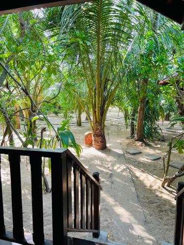 a porch with a view of a garden with palm trees at Ganesh Garden Beach Cabanas in Tangalle