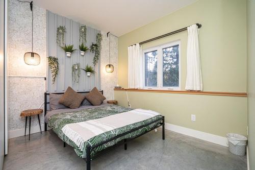 a bedroom with a bed and a window at Forest Retreat with Terrace near Horseshoe Bay Ferry and Marina in West Vancouver