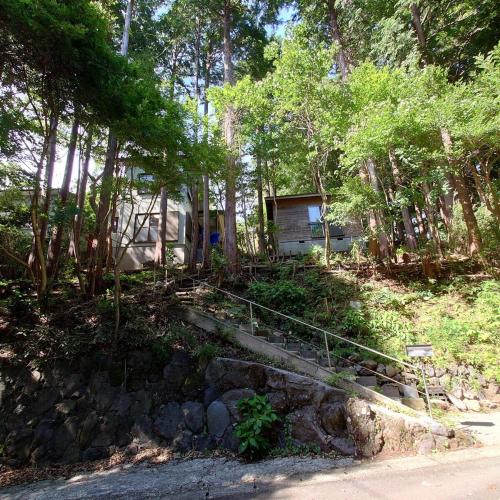 a house in the middle of a forest with trees at 熱川ヒュッテ in Higashiizu