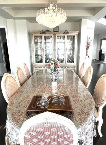 a dining room with a table with chairs and a chandelier at European-American Style Suite in Coquitlam