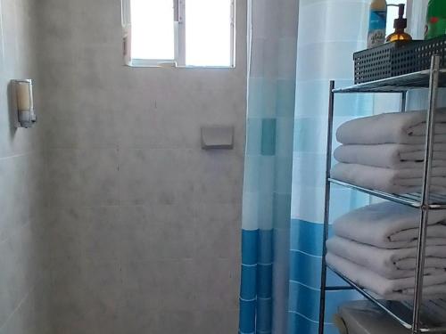 a shower with a stack of towels in a bathroom at Casa de descanso en privada, jardín, alexa,asador, mascota, facturamos in Toluca