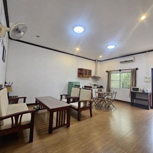 a living room with tables and chairs and a kitchen at Ali Xayathit Apartment & Hotel in Vientiane