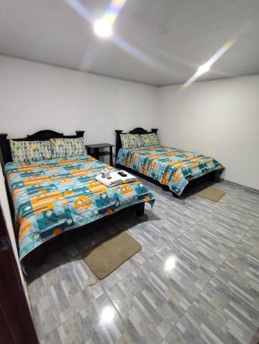 a bedroom with two beds in a room at Hotel La Terraza Raquireña in Ráquira
