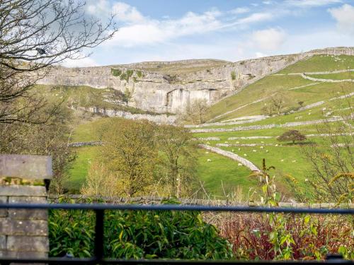 a view of a mountain from a fence at Cove View Cottage in Malham