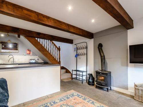 a kitchen and living room with a wood stove at Cove View Cottage in Malham