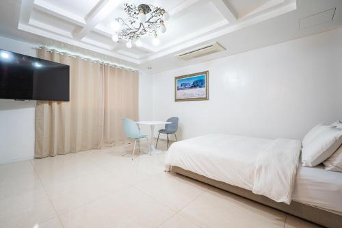 a bedroom with a bed and a table with chairs at Yeongdeungpo Ciel Hotel in Seoul