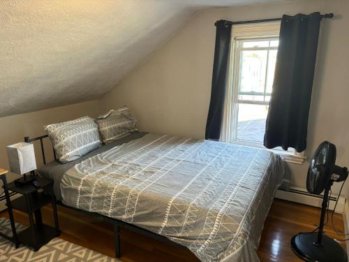 a bedroom with a bed and a window at HomeStay B&B in Boston - 3 locations in Dorchester in Boston