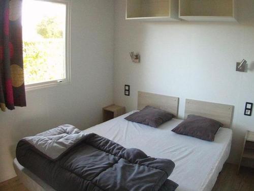 Ένα ή περισσότερα κρεβάτια σε δωμάτιο στο Mobil home 6 pers avec terrasse aux Achards - API-1-52-602