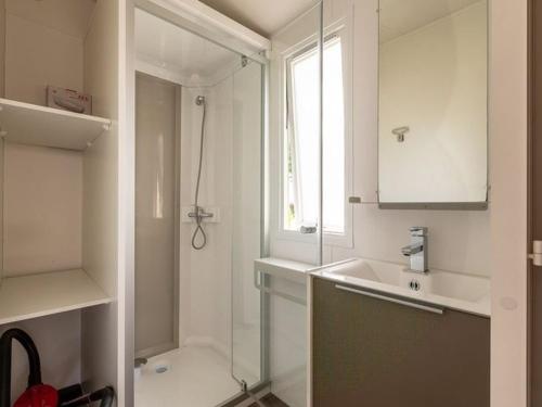 a white bathroom with a shower and a sink at Mobil-home avec terrasse à Bretignolles-sur-Mer, 6 pers., 3 chambres - API-1-52-389 in Brétignolles-sur-Mer