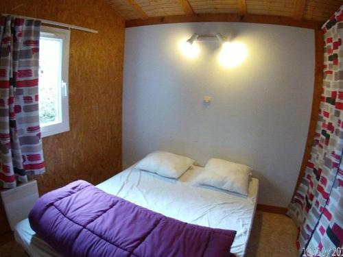 a small bedroom with a bed with white sheets at Chalet 5 pers - Terrasse - 2 Chambres - API-1-52-686 in La Mothe-Achard