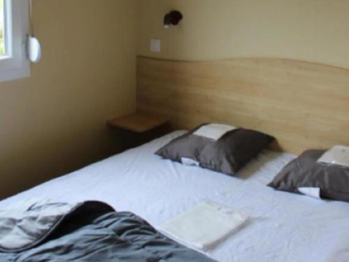 ein Schlafzimmer mit einem Bett mit zwei Kissen darauf in der Unterkunft Mobil home 4 pers avec terrasse à Mothe-Achard - API-1-52-383 in La Mothe-Achard