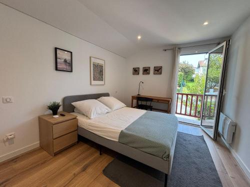 a bedroom with a bed and a large window at Belle maison 10 pers, piscine et jardin à Urrugne - FR-1-239-1146 in Urrugne