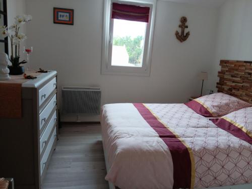 a bedroom with a bed and a dresser and a window at Maisonnette 4 pers, proche plage et commerces, parking - FR-1-476-247 in La Faute-sur-Mer