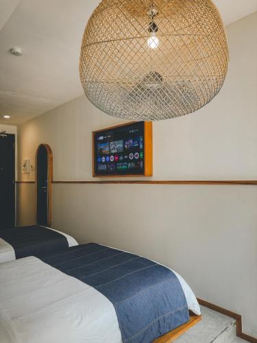 a bedroom with two beds and a tv on the wall at YATS Colony in Yogyakarta